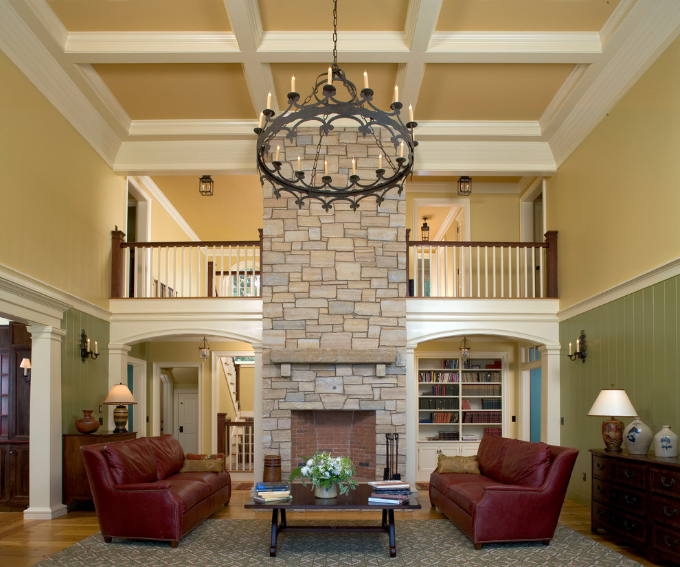 Cette photo montre un grand salon chic ouvert avec un sol en bois brun, une cheminée standard et un manteau de cheminée en pierre.
