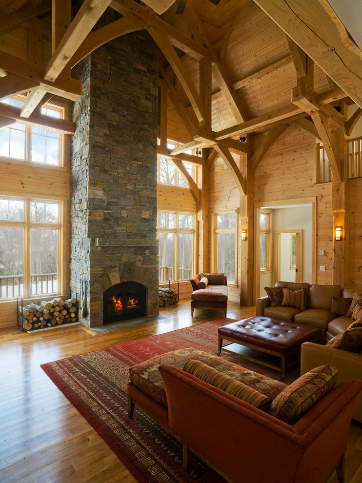 На фото: большая гостиная комната в классическом стиле с стандартным камином, фасадом камина из камня и коричневым диваном без телевизора