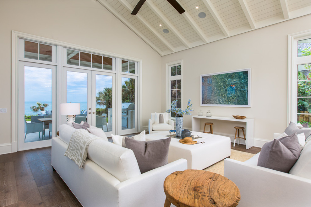 This is an example of a beach style living room in Miami with dark hardwood flooring and beige walls.