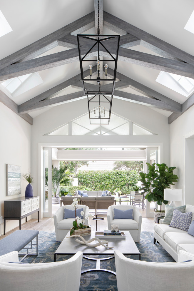 Example of a large beach style open concept light wood floor and beige floor living room design in Miami with gray walls, no fireplace and a wall-mounted tv