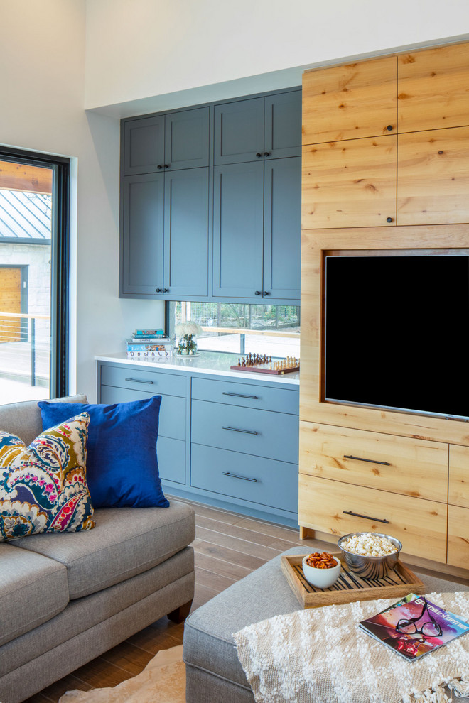 Mittelgroßes Landhaus Wohnzimmer ohne Kamin, im Loft-Stil mit Hausbar, weißer Wandfarbe, braunem Holzboden und Multimediawand in Austin