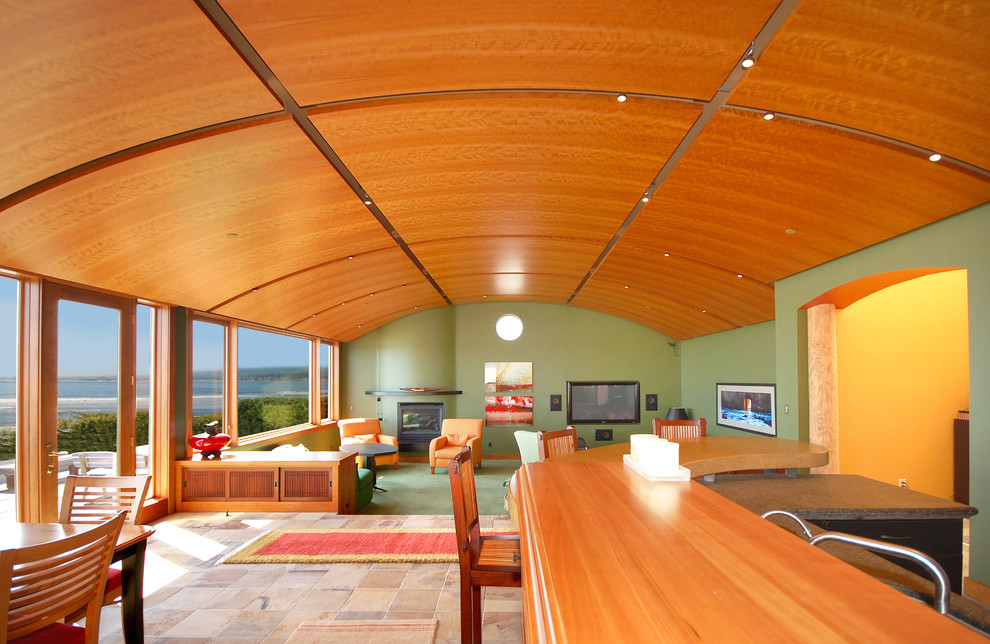 На фото: открытая гостиная комната в современном стиле с зелеными стенами, ковровым покрытием, стандартным камином, фасадом камина из штукатурки и телевизором на стене