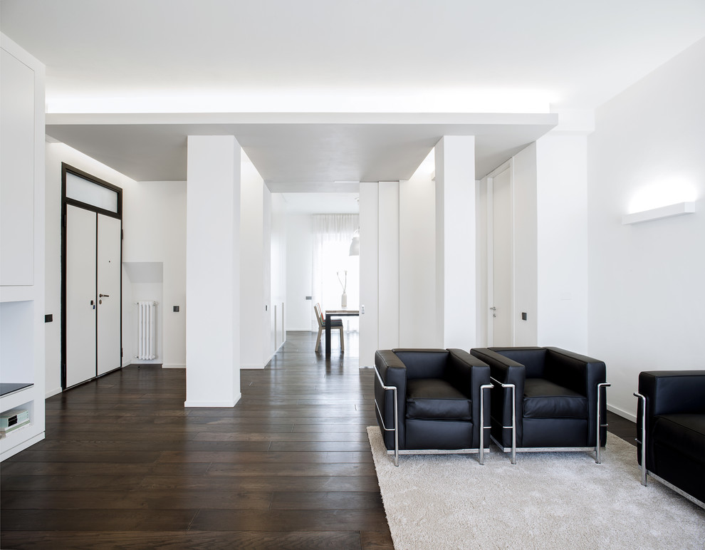 Ejemplo de salón para visitas abierto minimalista grande con paredes blancas, suelo de madera oscura, chimenea de doble cara, marco de chimenea de yeso y pared multimedia