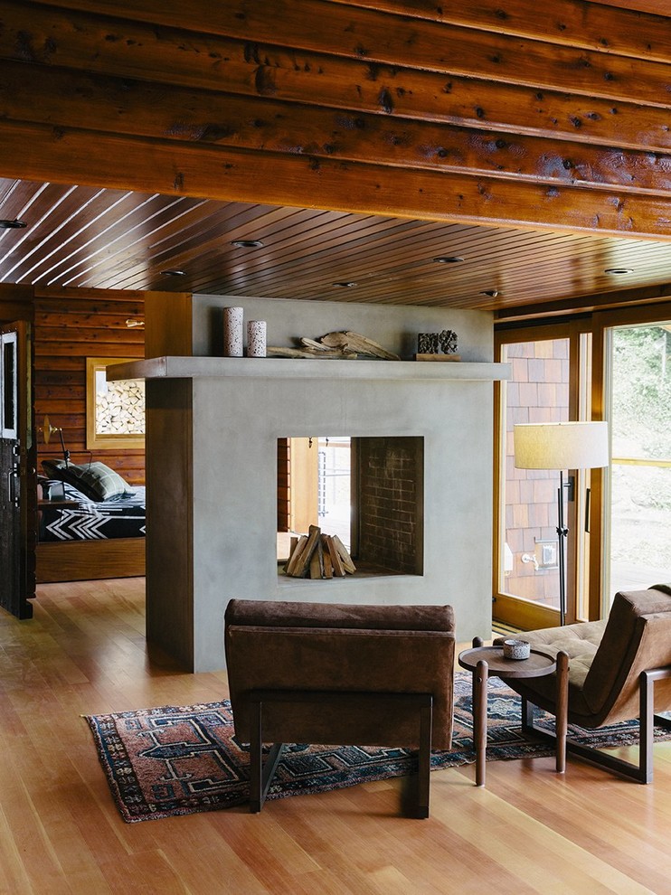 Uriges Wohnzimmer mit hellem Holzboden, Tunnelkamin und Kaminumrandung aus Beton in Vancouver