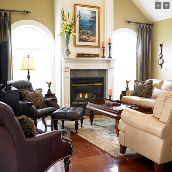 Mittelgroßes, Repräsentatives, Fernseherloses Klassisches Wohnzimmer mit beiger Wandfarbe, braunem Holzboden, Kamin und Kaminumrandung aus Stein in Calgary