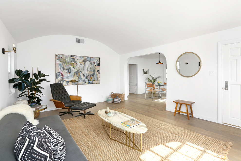 Danish medium tone wood floor living room photo in Los Angeles with white walls