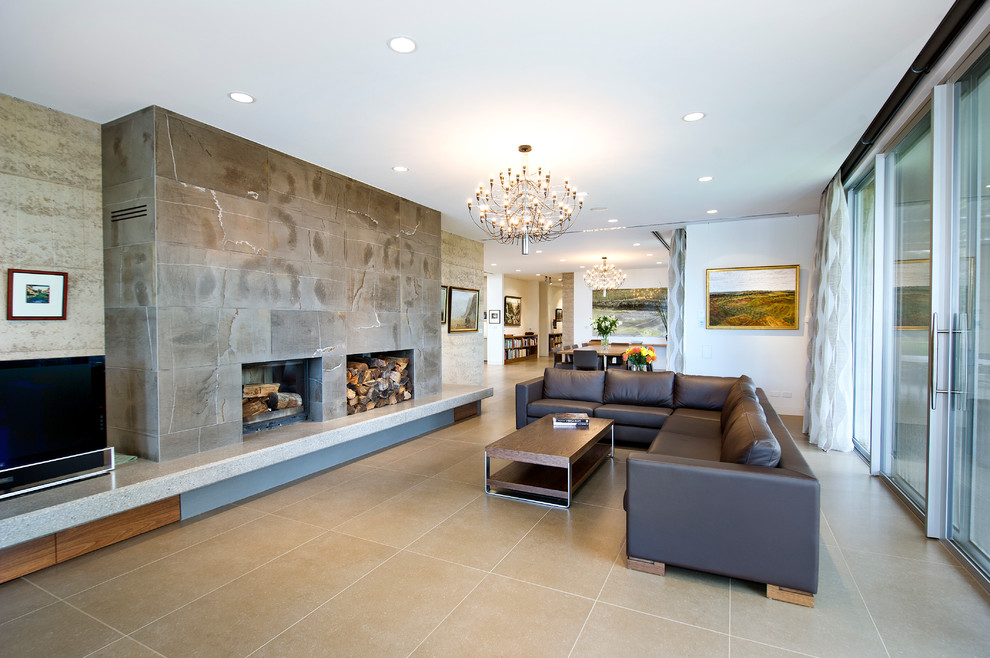 Пример оригинального дизайна: открытая гостиная комната в современном стиле с бежевыми стенами, печью-буржуйкой, фасадом камина из камня и отдельно стоящим телевизором