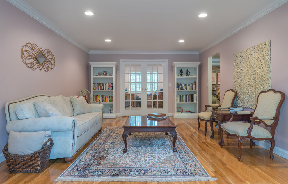 Exempel på ett mellanstort klassiskt separat vardagsrum, med ett finrum, rosa väggar, mellanmörkt trägolv och brunt golv