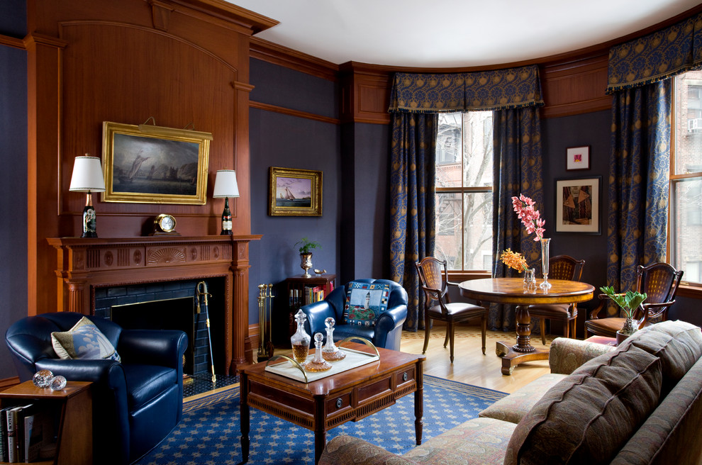 広いヴィクトリアン調のおしゃれなリビング (青い壁、淡色無垢フローリング、標準型暖炉、木材の暖炉まわり、テレビなし、ベージュの床) の写真