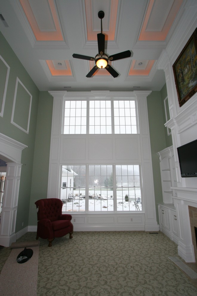 На фото: большая парадная, открытая гостиная комната в классическом стиле с зелеными стенами, ковровым покрытием, стандартным камином и фасадом камина из дерева с