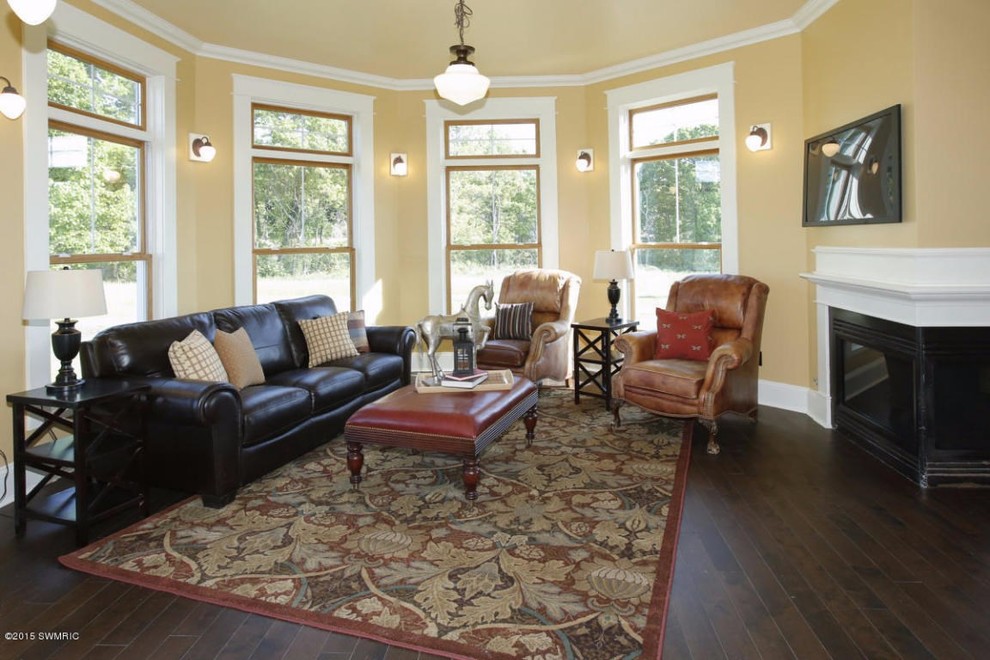 Mid-sized ornate open concept and formal dark wood floor living room photo in Grand Rapids with yellow walls, a corner fireplace, a wood fireplace surround and a wall-mounted tv