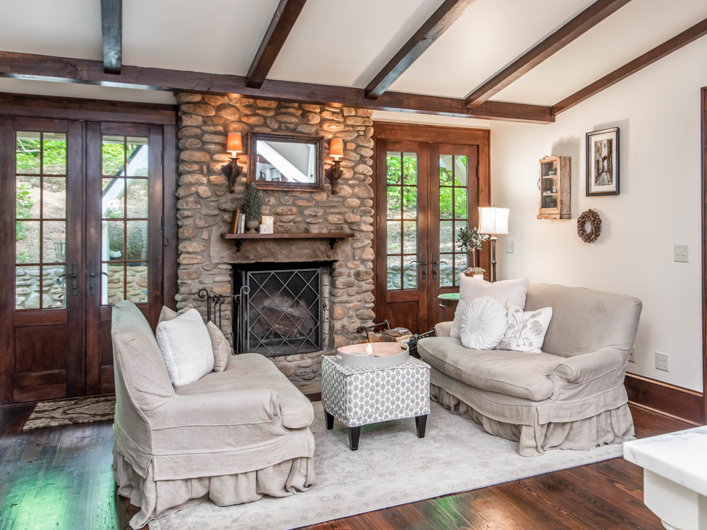 Medium sized farmhouse formal living room in Other with white walls, dark hardwood flooring, a standard fireplace, a stone fireplace surround, no tv and brown floors.