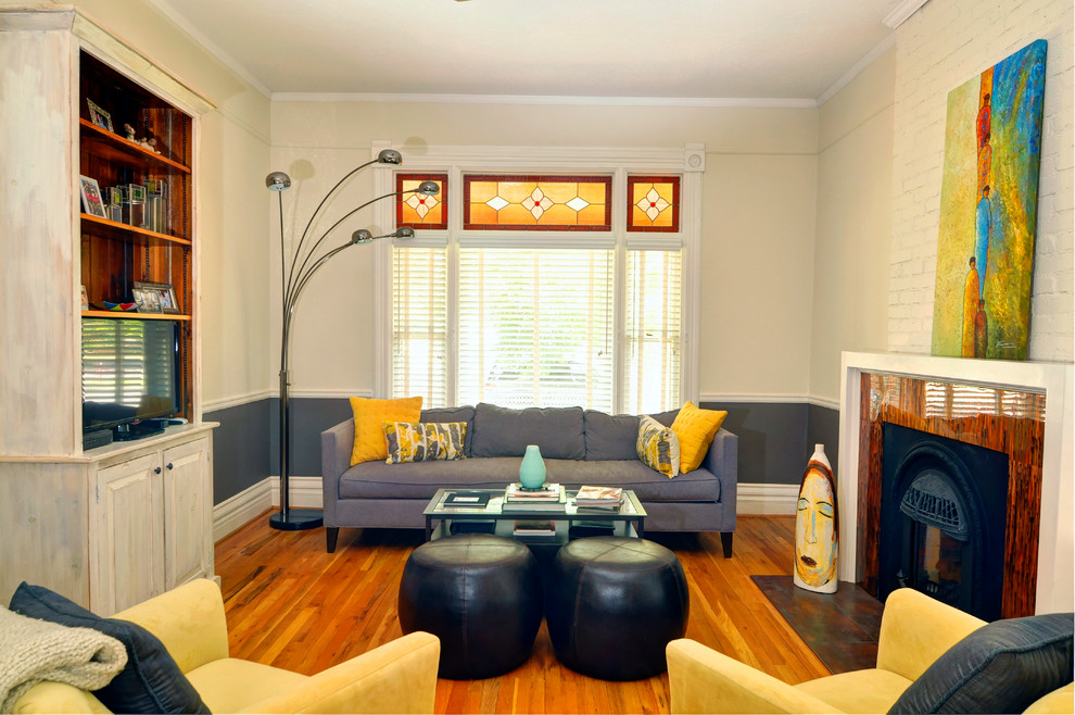 Пример оригинального дизайна: гостиная комната:: освещение в стиле неоклассика (современная классика) с бежевыми стенами, паркетным полом среднего тона и стандартным камином