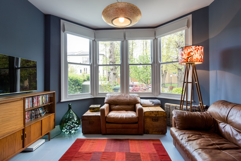 Idee per un soggiorno classico di medie dimensioni con libreria, pareti blu, pavimento in legno verniciato e pavimento bianco