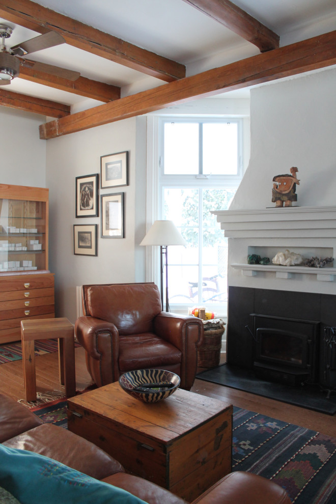 Idéer för ett mellanstort klassiskt separat vardagsrum, med blå väggar, mellanmörkt trägolv, en standard öppen spis, en fristående TV och brunt golv