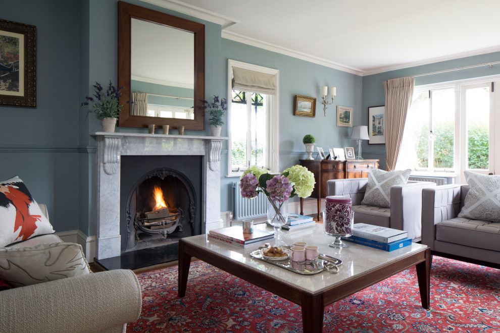 Aménagement d'un salon classique avec une salle de réception, un mur bleu, parquet foncé, une cheminée standard et un sol marron.