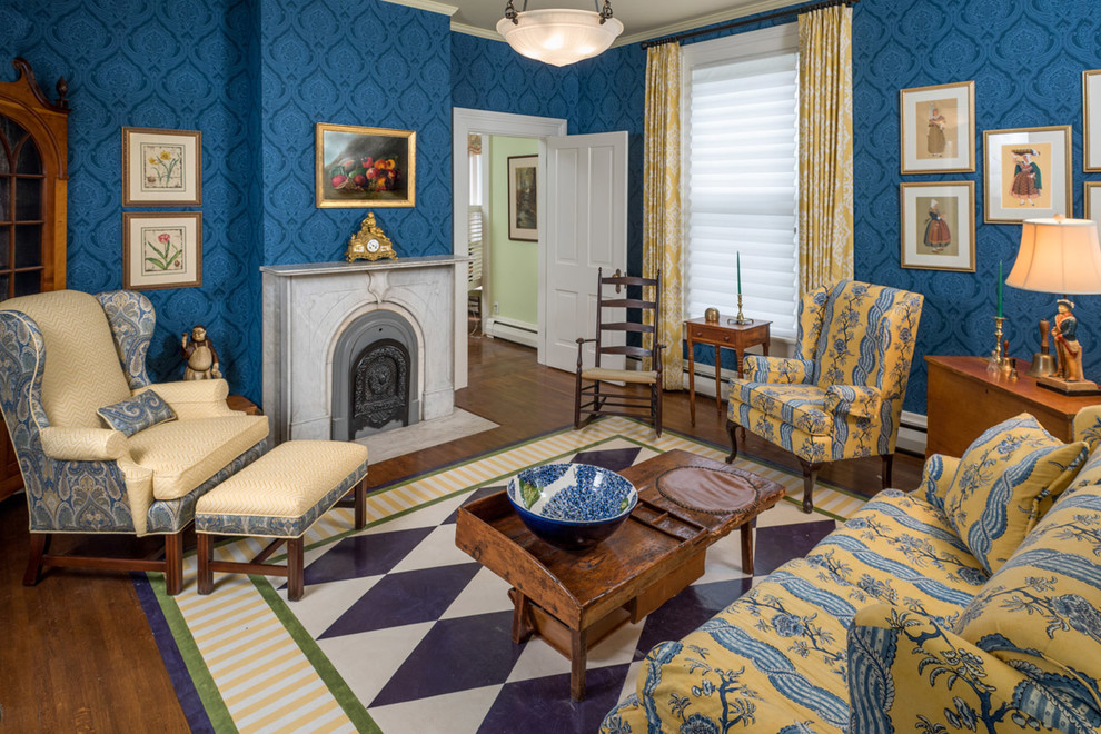 Exemple d'un salon victorien de taille moyenne et fermé avec une salle de réception, un mur bleu, un sol en bois brun, une cheminée standard, un manteau de cheminée en pierre, aucun téléviseur et un sol marron.