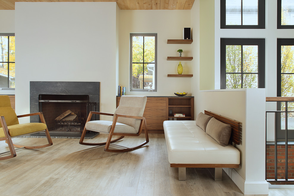 Идея дизайна: открытая гостиная комната среднего размера в стиле модернизм с белыми стенами, светлым паркетным полом, стандартным камином и фасадом камина из дерева
