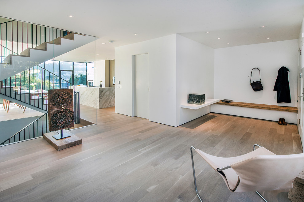Medium sized modern formal enclosed living room in San Francisco with white walls, light hardwood flooring, no fireplace, no tv and brown floors.