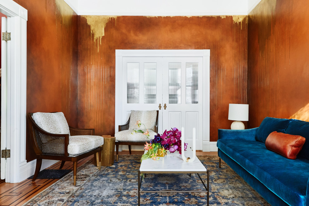 На фото: парадная, изолированная гостиная комната среднего размера в стиле фьюжн с оранжевыми стенами и паркетным полом среднего тона без камина, телевизора