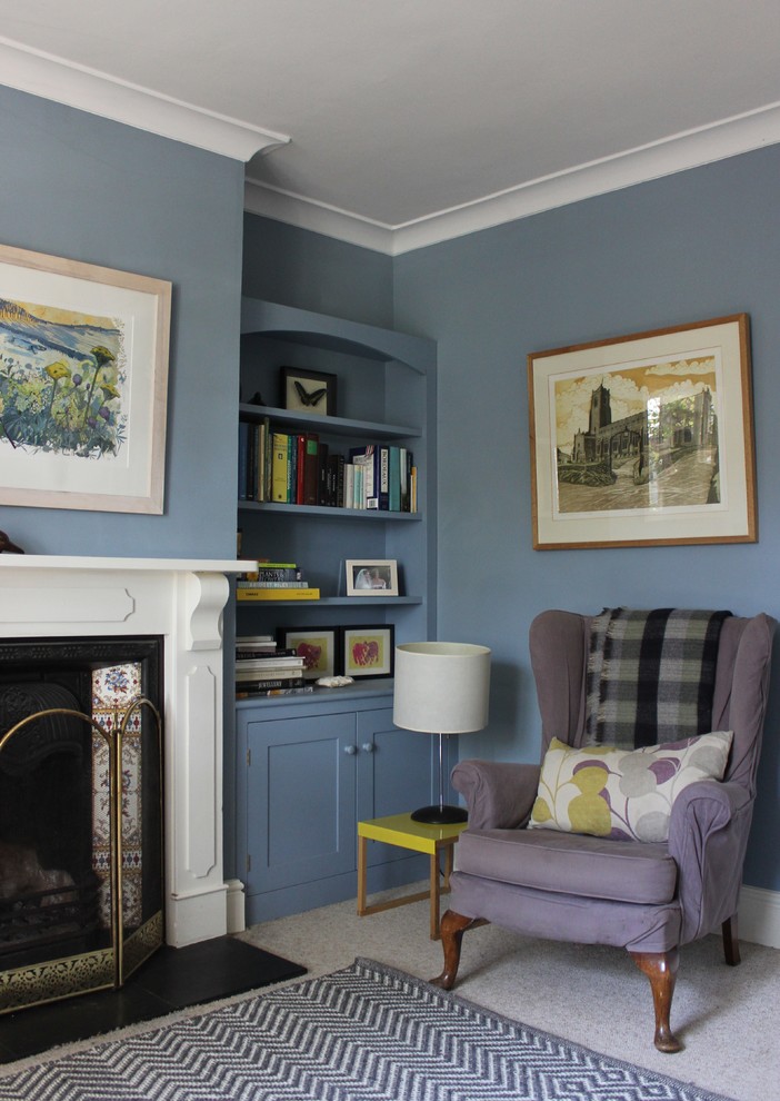 На фото: изолированная гостиная комната в стиле кантри с с книжными шкафами и полками, синими стенами и фасадом камина из дерева