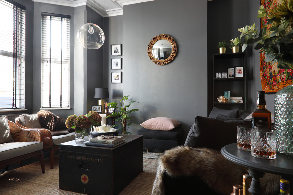 Klassisk inredning av ett mellanstort separat vardagsrum, med grå väggar, målat trägolv, en fristående TV och svart golv