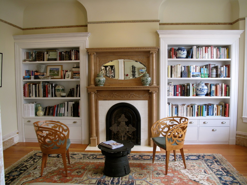 Inredning av ett klassiskt mellanstort separat vardagsrum, med ett bibliotek, en standard öppen spis och en spiselkrans i trä