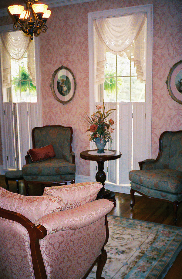 Cette photo montre un petit salon victorien fermé avec une salle de réception, un mur rose, un sol en bois brun et aucun téléviseur.