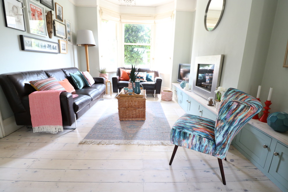 Mid-sized eclectic light wood floor living room photo in Cambridgeshire with blue walls