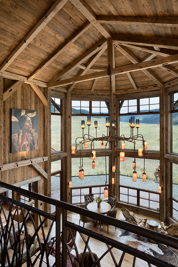 Large rustic open plan living room in Other with light hardwood flooring, a stone fireplace surround and a wall mounted tv.