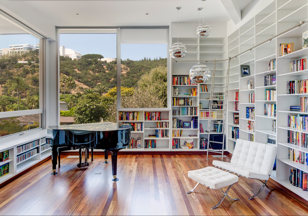 Immagine di un soggiorno minimal di medie dimensioni e chiuso con libreria, pareti bianche, pavimento in legno massello medio e pavimento marrone
