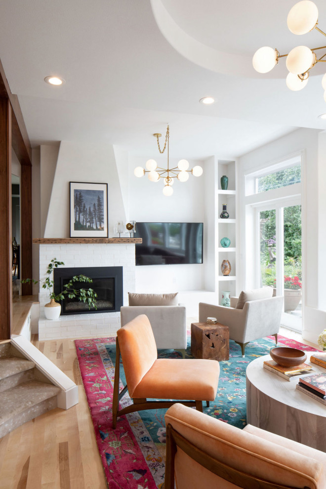Foto di un soggiorno classico di medie dimensioni e aperto con pareti bianche, parquet chiaro, camino classico, TV a parete e pavimento beige