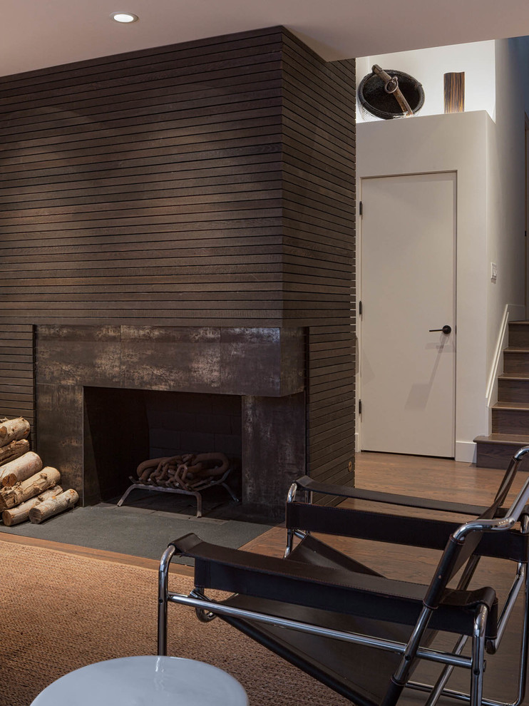 Пример оригинального дизайна: гостиная комната в стиле ретро с угловым камином и фасадом камина из металла