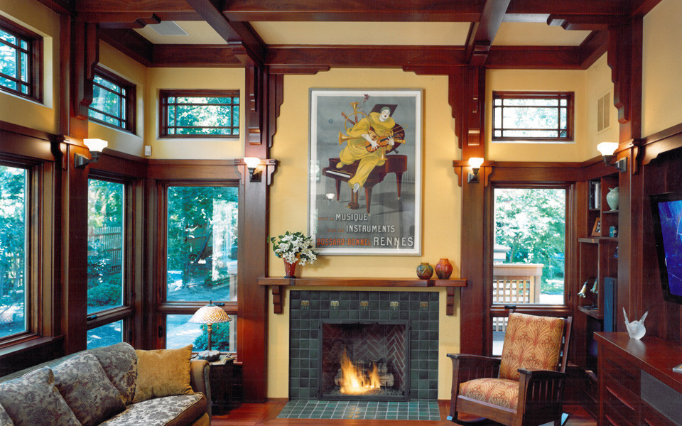 Amerikansk inredning av ett litet separat vardagsrum, med gula väggar, mörkt trägolv, en standard öppen spis och en spiselkrans i trä