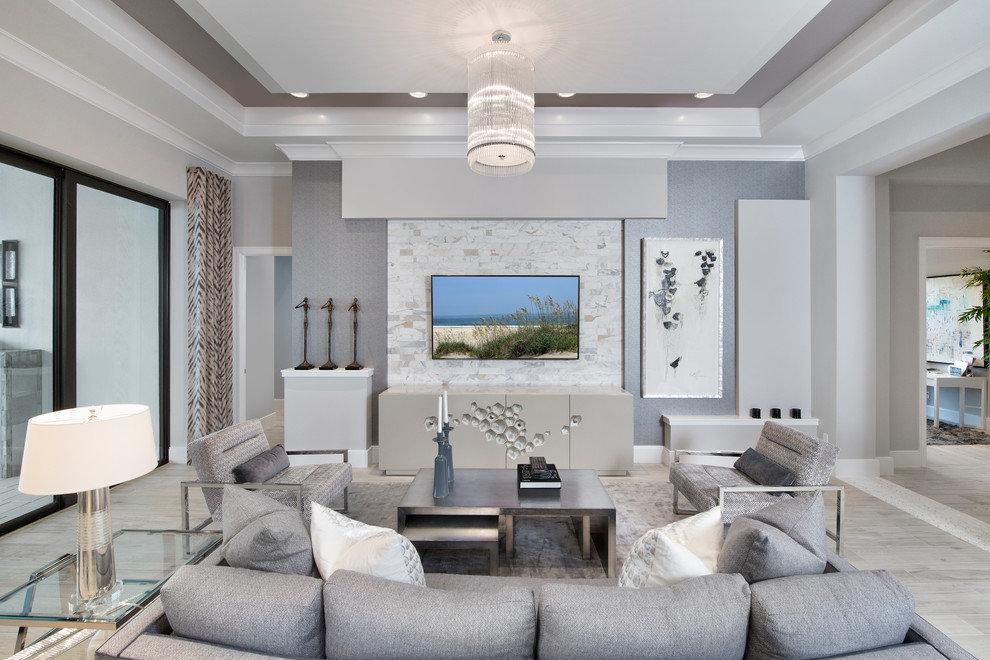 Стильный дизайн: открытая гостиная комната в современном стиле с серыми стенами, телевизором на стене и серым полом - последний тренд