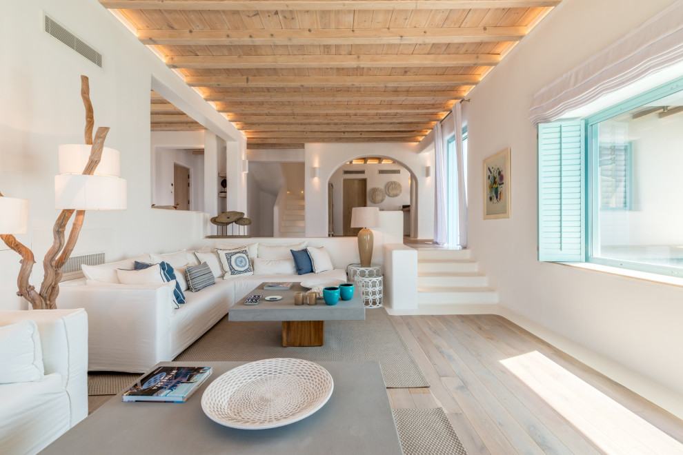 Foto de salón abierto marinero con paredes blancas, suelo de madera clara, suelo beige, vigas vistas y madera