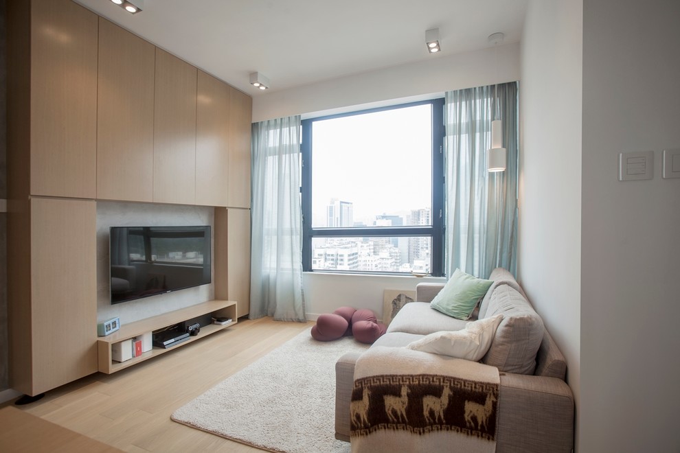 Mittelgroßes, Abgetrenntes Modernes Wohnzimmer mit grauer Wandfarbe, braunem Holzboden und TV-Wand in Hongkong
