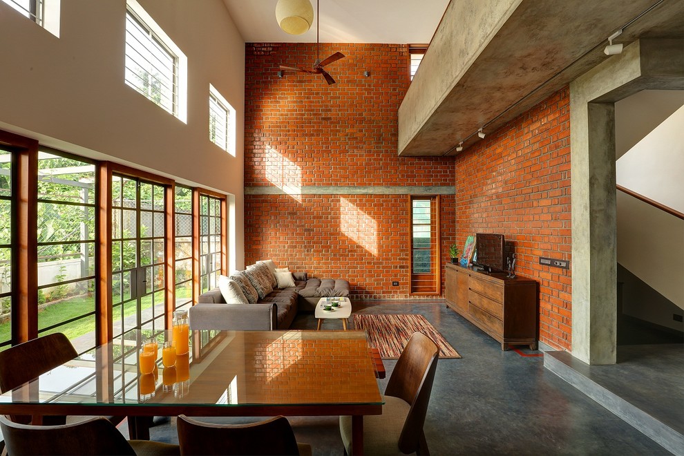 Esempio di un soggiorno industriale aperto con pareti rosse, pavimento in cemento, TV autoportante e pavimento grigio