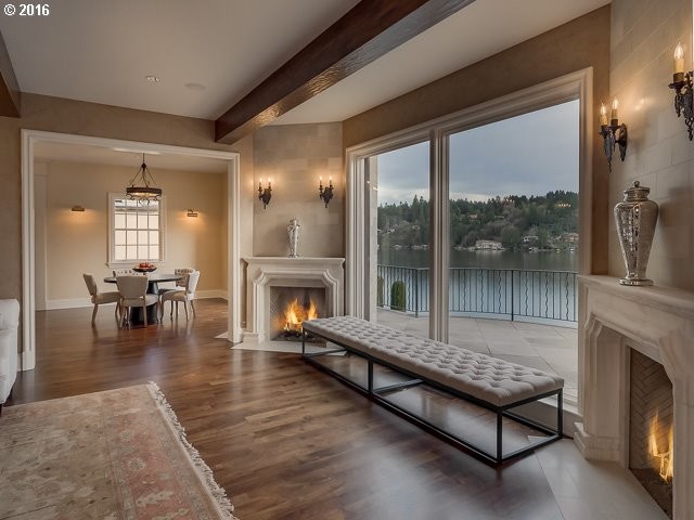 Modelo de salón para visitas cerrado mediterráneo grande sin televisor con paredes beige, suelo de madera en tonos medios, chimenea de esquina, marco de chimenea de piedra y suelo marrón