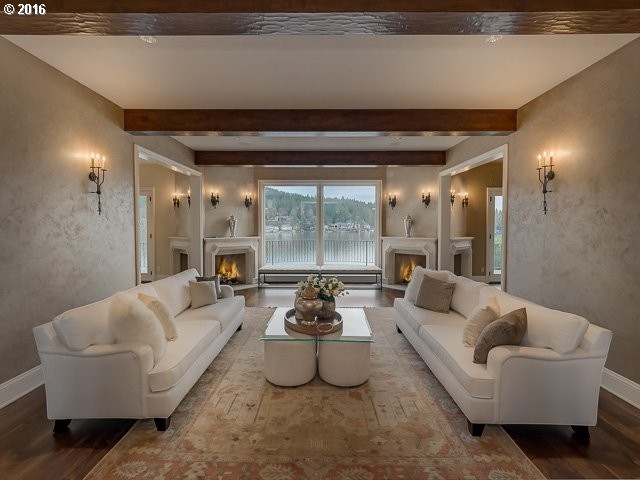 Großes, Repräsentatives, Abgetrenntes Mediterranes Wohnzimmer mit beiger Wandfarbe, braunem Holzboden, Eckkamin, Kaminumrandung aus Stein und braunem Boden in Portland