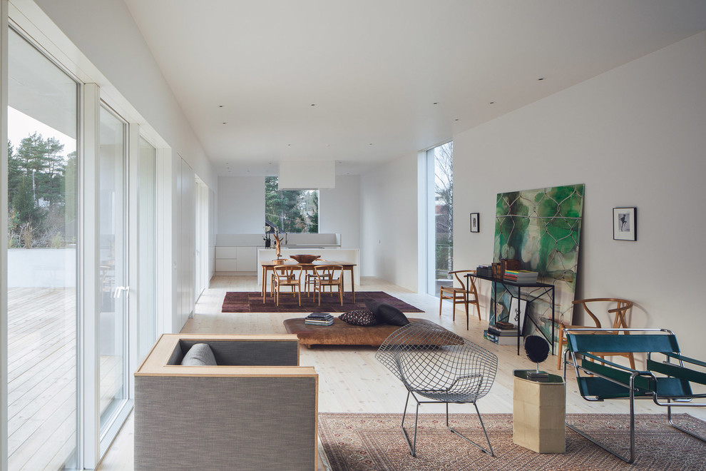 На фото: открытая гостиная комната среднего размера в скандинавском стиле с белыми стенами и светлым паркетным полом без камина, телевизора