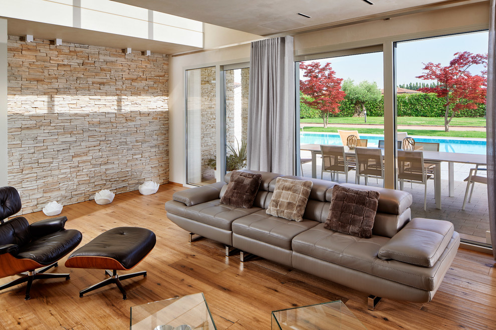 Exemple d'un salon tendance ouvert avec un mur beige, un sol en bois brun, un sol marron et une cheminée double-face.