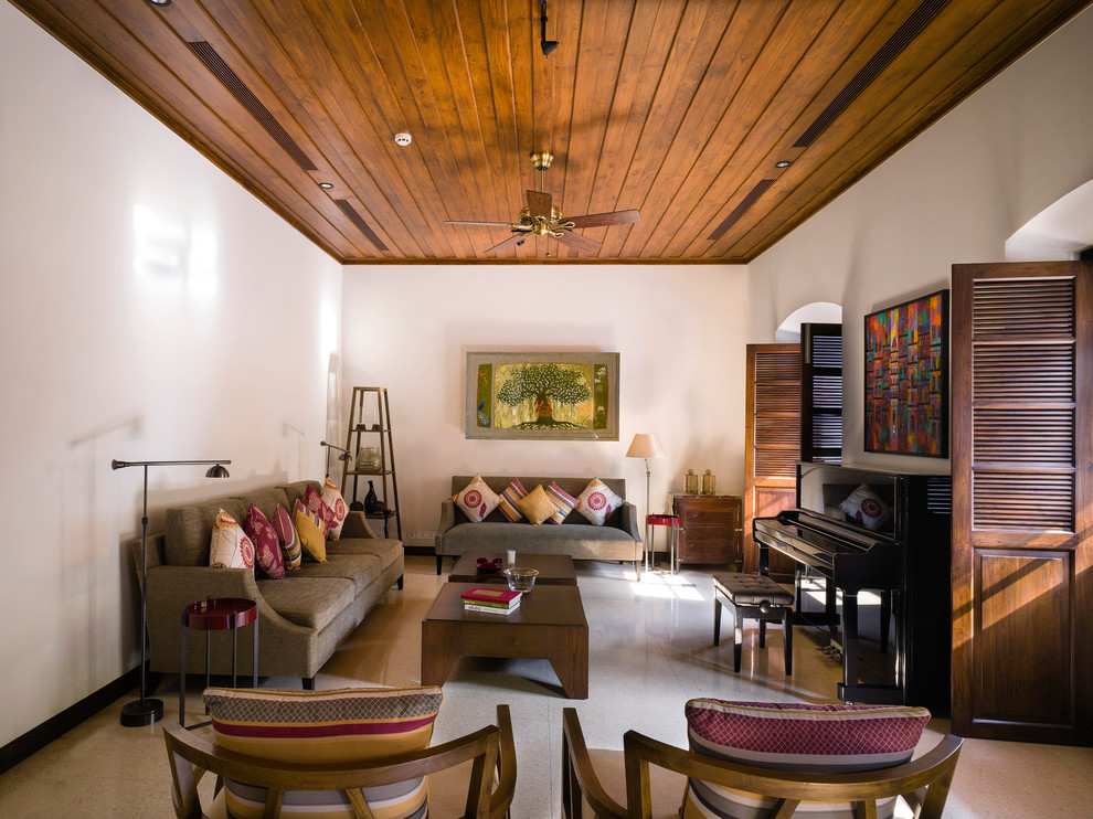 Immagine di un soggiorno tropicale chiuso con sala della musica, pareti bianche e pavimento beige