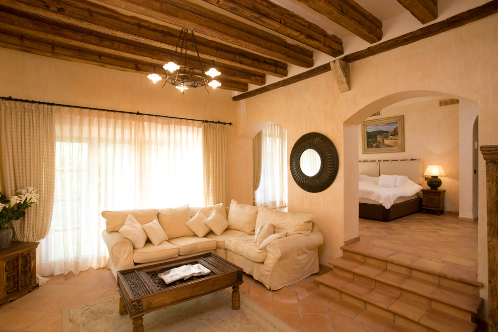 Immagine di un soggiorno country di medie dimensioni e aperto con sala formale, pareti beige, pavimento in terracotta e nessun camino