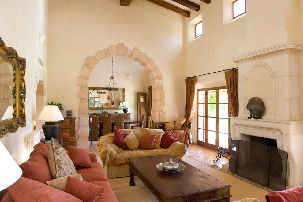 Ejemplo de salón para visitas cerrado campestre de tamaño medio sin televisor con paredes beige, todas las chimeneas, marco de chimenea de piedra y arcos