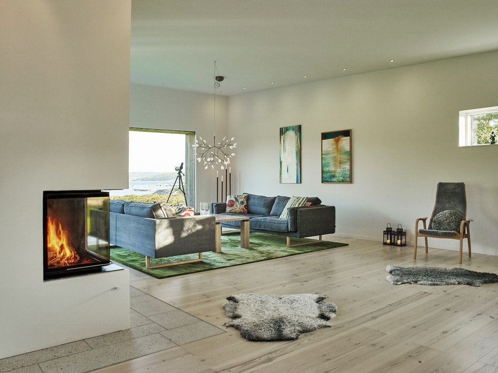 Imagen de salón cerrado escandinavo sin televisor con paredes blancas, suelo de madera clara y suelo beige