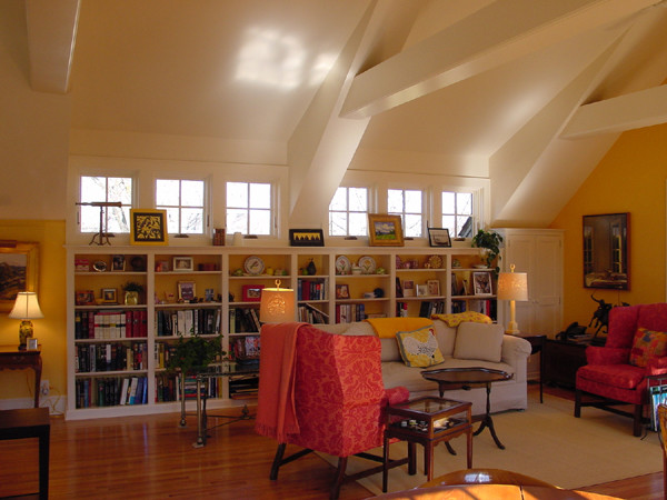 Idéer för att renovera ett mellanstort vintage allrum med öppen planlösning, med gula väggar, mellanmörkt trägolv och ett bibliotek