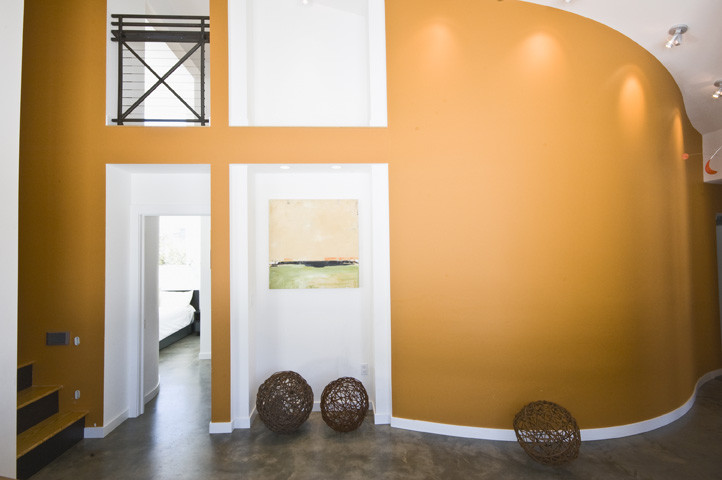 Immagine di un grande soggiorno country chiuso con pareti arancioni e pavimento in cemento