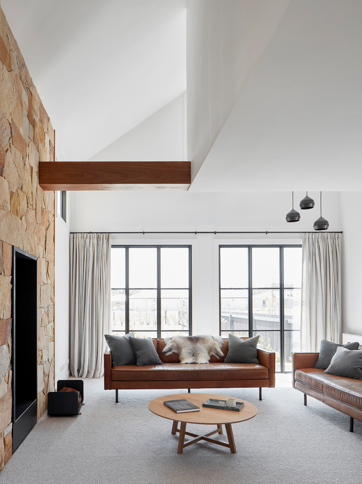 Mittelgroßes, Fernseherloses, Offenes Landhaus Wohnzimmer mit Hausbar, weißer Wandfarbe, Teppichboden, Kaminofen, Kaminumrandung aus Metall und grauem Boden in Melbourne