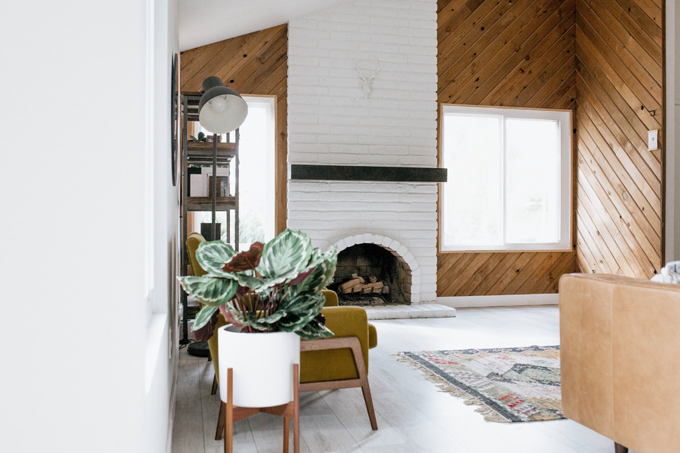 Idee per un soggiorno minimal con pareti marroni, pavimento in legno verniciato, camino classico, cornice del camino in mattoni e pavimento bianco